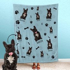 a black and white dog sitting next to a blue blanket with paw prints on it