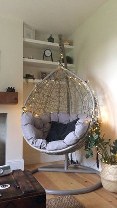 a living room with a hanging chair and fireplace