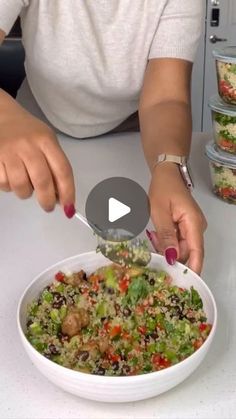 a woman is cutting into a salad in a bowl