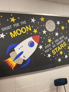 a classroom wall decorated with stars and a rocket ship on it's side that says shoot for the moon even if you miss, you'll be among the stars