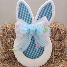 a paper plate shaped like an easter bunny with a blue bow on it's head