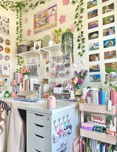 a room with lots of books and pictures on the wall, plants growing over the desk