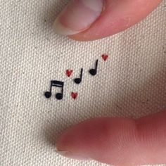 someone is stitching music notes and hearts on their fingers