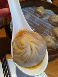 a spoon full of dumplings on top of a plate