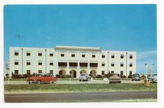 cars parked in front of a large white building