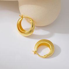 These exquisite hoops seamlessly blend the enduring beauty of sterling silver with a radiant gold finish, creating a versatile accessory suitable for any occasion. Crafted with precision, they offer a sleek and minimalist design that effortlessly elevates your style. Embrace the understated luxury of these enduring earrings, designed to complement your individual fashion sense with grace and ease, adding a touch of timeless charm and sophistication to every ensemble.Classic Thick Gold Hoops;Inne Thick Gold Hoops, Understated Luxury, Silver Pieces, Gold Hoops, Body Oil, Plastic Free, Fashion Sense, Gold Finish, Rhodium Plated