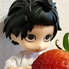 a close up of a toy holding a strawberry