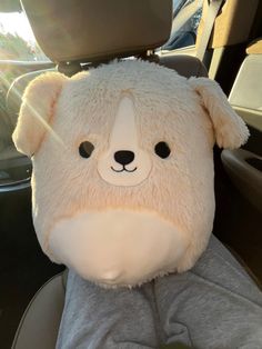 a teddy bear sitting in the back seat of a car with it's head up