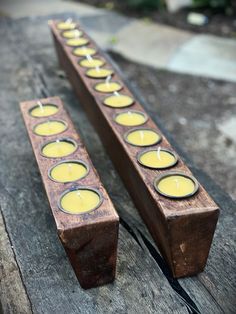 two wooden candles sitting on top of a table next to each other with lit candles in them