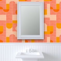 a white sink sitting under a bathroom mirror next to a wall mounted faucet