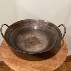 a large metal bowl sitting on top of a wooden table