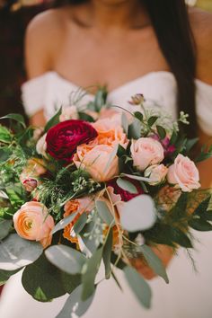 a woman holding a bouquet of flowers in her hands