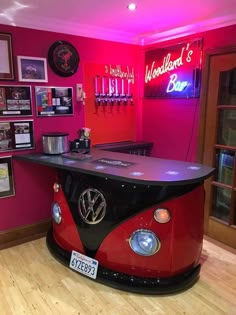 a red and black vw bus bar with neon signs on the wall behind it