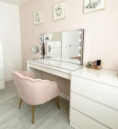 a pink chair sitting in front of a white desk with a mirror on top of it