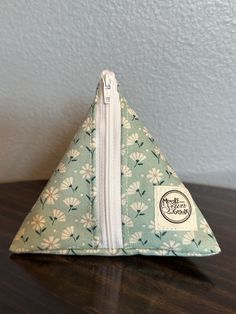 a small triangle shaped pouch sitting on top of a wooden table