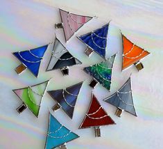 a group of colorful stained glass pieces sitting on top of a white table next to each other