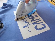 an iron is on top of a blue t - shirt