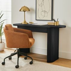 a desk with a chair, lamp and pictures on the wall