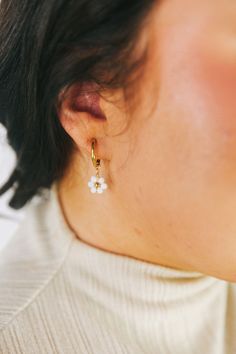 Spruce up your outfit with these playful Dropping Daisies Earrings! These gold hoops feature a charming white beaded flower design with a gold center, adding a touch of whimsy to your look. Perfect for adding a fun and unique twist to any outfit. Gold earrings White beaded flower design with gold center Huggie/hoop earrings with dropped flowers Beaded Huggie Earrings, Trendy White Earrings With Flower Charm, Dainty White Earrings For Spring, Dainty White Dangle Flower Earrings, White Jewelry With Matching Earrings For Spring, Spring White Jewelry With Matching Earrings, White Flower Hoop Earrings With Flower Charm, Trendy White Hoop Earrings With Pearl Drop, Handmade White Hoop Flower Earrings