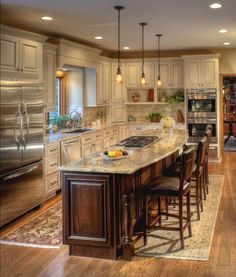 a large kitchen with an island in the middle and lots of counter space on one side