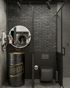 a bathroom with a toilet, washer and dryer in it next to a brick wall