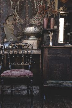 an old chair sitting in front of a dresser