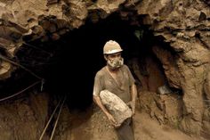 a man wearing a gas mask standing in front of a tunnel with rocks on the ground