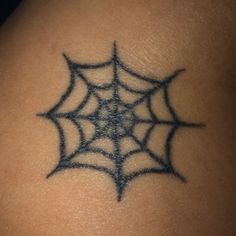 a spider web tattoo on the back of a woman's shoulder