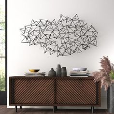 a modern sideboard with geometric shapes on the wall