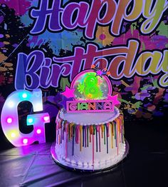 a birthday cake sitting on top of a table next to a glitle sign