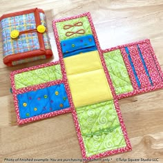 two pieces of fabric sitting on top of a wooden floor next to an empty wallet