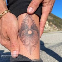 a man holding his leg with a tattoo on it's arm and the other hand