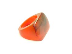 an orange glass ring sitting on top of a white surface