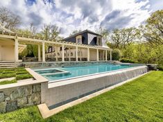 an outdoor swimming pool in the middle of a yard with grass and trees around it