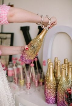 a woman is holding a champagne bottle in front of many other bottles on the table