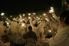 a group of people holding sparklers in the air