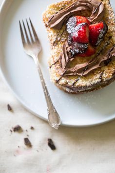 a piece of cake with chocolate frosting and strawberries on top