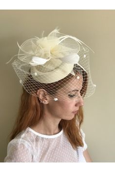 This is a handcrafted felt wedding fascinator hat, with flower looking tulle, delicate feathers, and birdcage veil.  The color is beige, goes with many different dress colours such as white, ivory, ecru, and blue. Powdery pink is also available in this listing. It is made in a standard one-size, and it has a hair clip under it for easy wearing on any hair style. This model and other models are available in various colors, check them out from here: https://www.etsy.com/shop/ArtisanTulipBridal?sec Feathered Mini Hat Headband For Weddings, Feathered Wedding Fascinator For Royal Ascot, Elegant Feathered Fascinator For Vintage Events, Feathered Fascinator For Wedding At Royal Ascot, Fitted Feather Fascinator For Wedding, Feather Fascinator For Wedding And Royal Ascot, Elegant Feather Fascinator For Vintage Events, Vintage Wedding Fascinator With Feathers, Elegant Cream Fascinator For Vintage Events