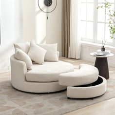 a living room with white furniture and a clock on the wall