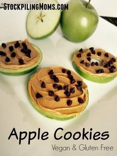 three apples with chocolate chips on them next to some green apples