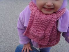 a small child wearing a pink knitted hat and scarf