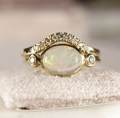 "Minimalist modern 14k yellow gold opal bezel setting ring.  10mm x 7mm oval cabochon genuine Ethiopian opal with 14k solid gold  band and bezel setting. 2 diamonds accented each side.Opal is October birthstone , 14th and 18th Anniversary gemstone. Opal is often associated with inspiration, passion and love. It's symbolizes faithfulness and confidence. Opal is associated with the Crown Chakra. THIS LISTING ONLY FOR OPAL DIAMOND RING. DETAILS ABOUT THE RING, MATERIAL AND STONES  Band is 14k yello Modern 14k Gold Oval Opal Ring, Modern Oval Opal Ring In Yellow Gold, Modern Oval Opal Ring With Bezel Setting, Modern Oval Yellow Gold Opal Ring, Modern Yellow Gold Oval Opal Ring, Modern Oval Opal Ring, Modern Oval Cabochon Opal Ring As Gift, Modern Gold Oval Opal Ring, Modern Oval Opal Ring For Wedding