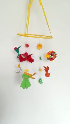 an origami mobile is hanging on the wall with paper stars and other decorations