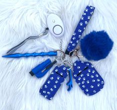 a keychain with several items attached to it on a white fur surface next to scissors and hairdryer