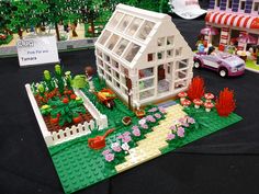 a lego house is on display in front of other toy houses and toys around it