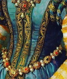 an ornately decorated blue and gold dress with pearls on the collar, chest and arm