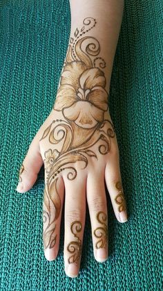 a woman's hand with hennap on it and flowers painted on the palm