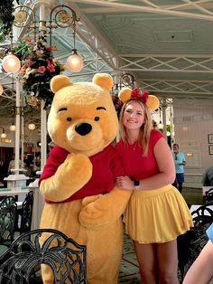 a woman standing next to a giant teddy bear