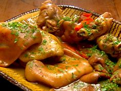 a plate filled with meat and vegetables covered in gravy on top of a wooden table