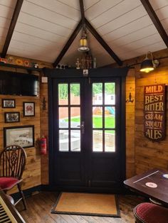 the inside of a small cabin with wood paneling and glass doors that lead to a patio